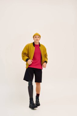 Genç adam kendine güvenerek şık bir şekilde poz veriyor, yapay bacakla modayı ön plana çıkarıyor..