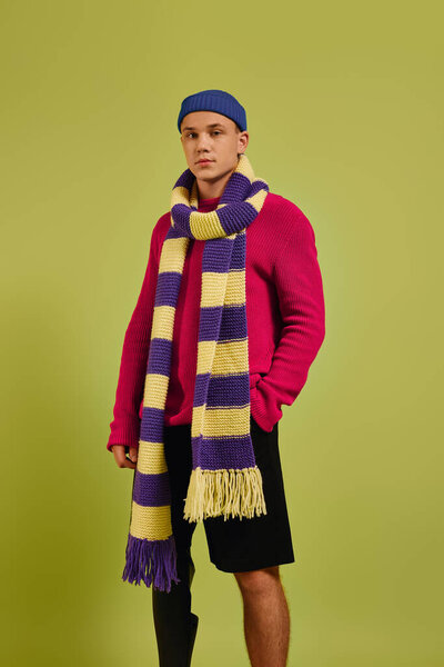 Stylish young man confidently poses in fashionable outfit featuring a prosthetic leg.