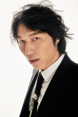 Şık genç adam kendine güvenerek parlak bir arka plana karşı modaya uygun poz veriyor..