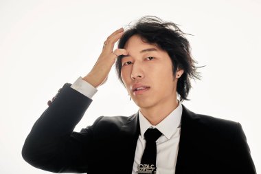 Yakışıklı Asyalı erkek, modaya uygun bir poz verirken cazibesini sergiliyor..