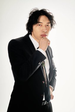 Yakışıklı Asyalı genç adam şık bir kıyafet sergilerken cazibe ve güven yayıyor..