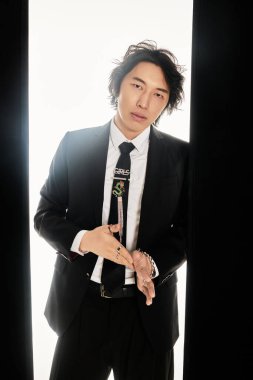 Resmi giyinmiş yakışıklı genç adam şehir ortamında poz verirken kendine güveniyor..