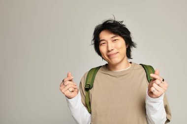 Modern görünümlü yakışıklı genç adam, evde rahat poz verirken kendine güven yayıyor..