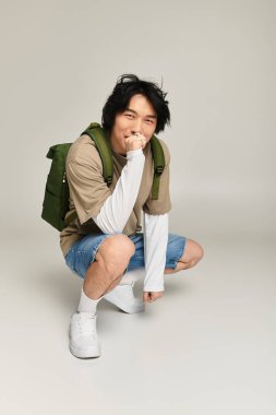 Yakışıklı genç bir adam modaya uygun bir şekilde poz verir, gençlik tarzını ve modasını benimser..