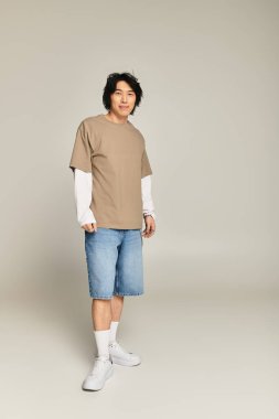 Yakışıklı genç bir adam modaya uygun tarzını modern bir ortamda rahat bir kıyafetle sergiliyor..