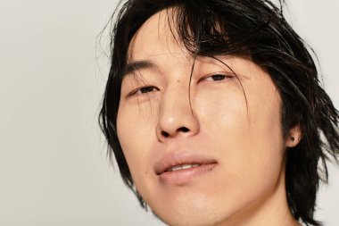 Çekici Asyalı genç adam kendine güvenerek, şık ve çağdaş bir görünüm sergiliyor..