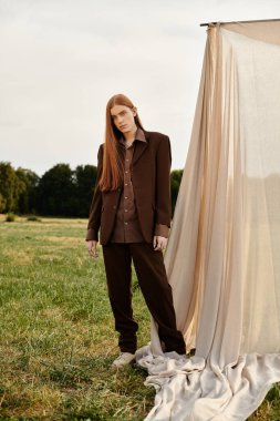 Uzun saçlı genç bir adam modern modayı doğal bir ortamda modelliyor..