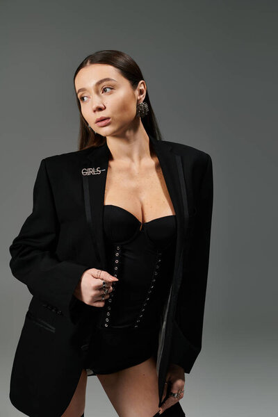 Очаровательная молодая женщина воплощает изящество и стиль, уверенно позируя в модной одежде