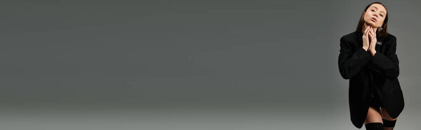 Pretty gymnast confidently displays her flexibility and fashion sense in a striking pose indoors.