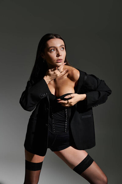 Молодой гимнаст демонстрирует гибкость и стиль в художественной позе на темном фоне.