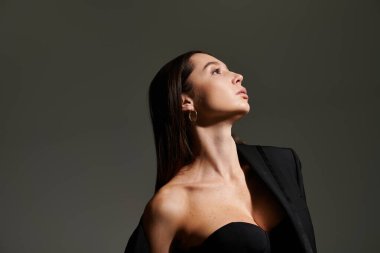 Genç ve güzel bir jimnastikçi çarpıcı bir poz veriyor. Şık bir elbise içinde zarafet ve tarz yayıyor..