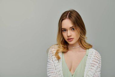 Genç bir kadın şık bir bahar elbisesi sergiliyor. Kendine güveni ve tarzı herkesi büyülüyor..