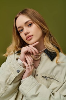 Genç bir kadın zarif poz veriyor, şık tarzıyla ve şık bahar aksesuarlarıyla hava atıyor..