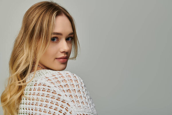 В стильном месте молодая женщина поворачивает голову, демонстрируя свой шикарный весенний наряд.