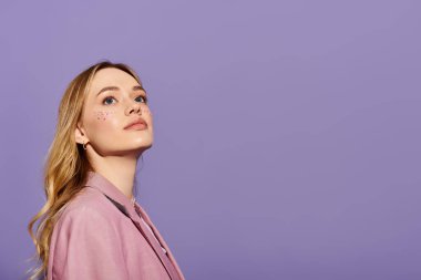 Kendine güvenen genç bir kadın şık bahar kıyafetini pastel bir arka planda sergiliyor..