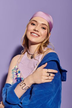 Şık bir bahar elbisesi içinde ışıl ışıl genç bir kadın ışıl mor bir arka plana karşı neşe saçıyor..