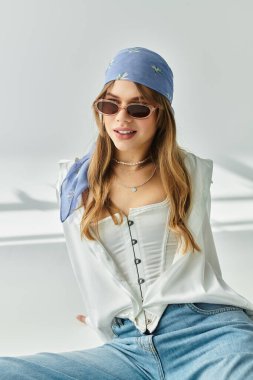 Genç bir kadın şık bir stüdyo ortamında gençlik enerjisi yayarak bahar modasını sergiliyor..