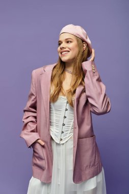 Genç bir kadın parlak mor bir arka plana karşı şık bir bahar elbisesi modelliyor, neşe saçıyor..