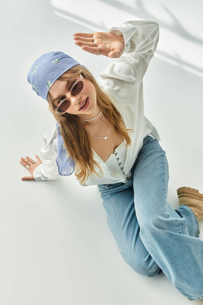 A woman in a playful spring outfit shines with youthful energy in a bright studio.