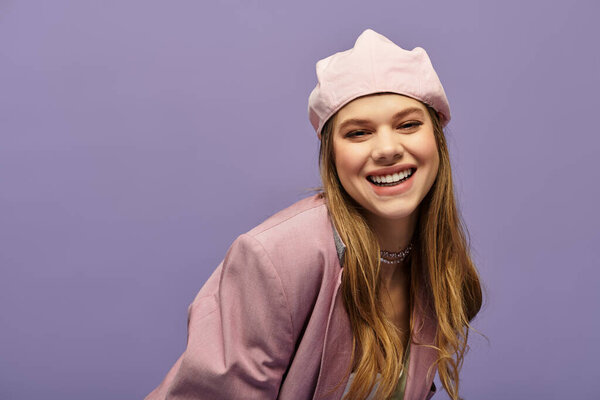 Молодая женщина излучает счастье в модном весеннем наряде на ярком фиолетовом фоне.