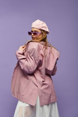 Genç bir kadın canlı bir stüdyoda neşeli bir poz verirken şık bir bahar kıyafeti sergiliyor..