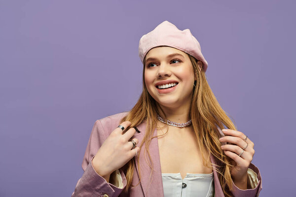 Очаровательная молодая женщина демонстрирует свой модный весенний наряд на ярком фиолетовом фоне студии.