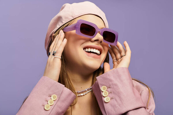 Молодая женщина демонстрирует модный весенний наряд на игривом фиолетовом фоне, излучая радость.