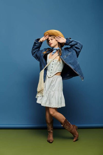 Молодая женщина ставит игривую позу в модном джинсовом пиджаке, вызывая радость весны.