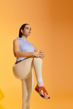 Genç bir atletik kadın, dinamik bir duruşla gücünü ve dikkatini gösteriyor..