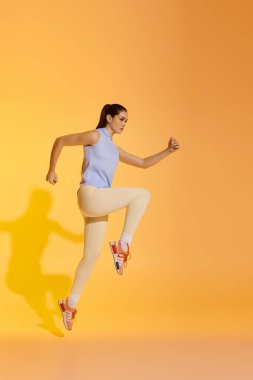 Dinamik atletik kadın coşku ve kararlılıkla antrenman yaparken yüksek bir sıçrama yapıyor..