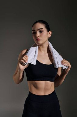 Kendine güvenen genç kadın şık bir stüdyoda atletizm antrenmanına hazırlanıyor..