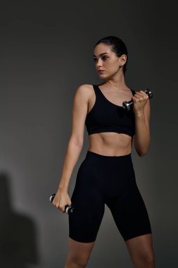 Sportif genç bir kadın, ağırlıklarını düzgün bir şekilde kaldırırken güç ve kararlılığı somutlaştırır..