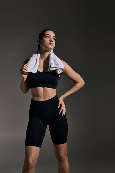 Confident young woman in athletic wear showcases her fitness and determination after a workout.