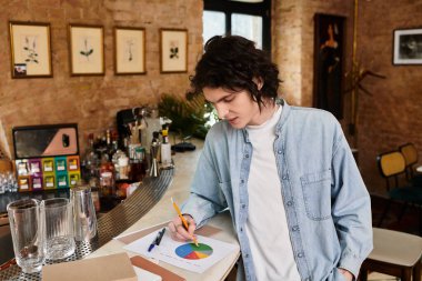 Genç adam boş zamanlarında modaya uygun bir kafede canlı grafikler çiziyor..