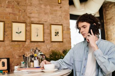 Tuhaf bir kafede, genç ve yakışıklı bir adam bir fincanın tadını çıkarırken bir telefon görüşmesi yapıyor..