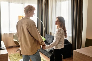 Genç bir çift şık bir otel odasında birlikte hassas bir anın tadını çıkarır..