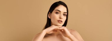 Parlak tenli genç bir kadın stüdyo ortamında zarifçe poz verir.