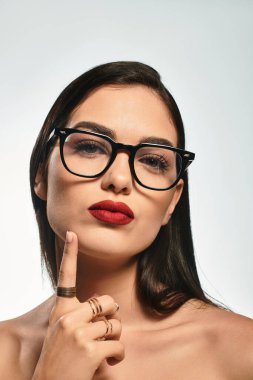 Kendine güvenen genç bir kadın çekici bir ifadeyle poz veriyor, güzelliğini gösteriyor..