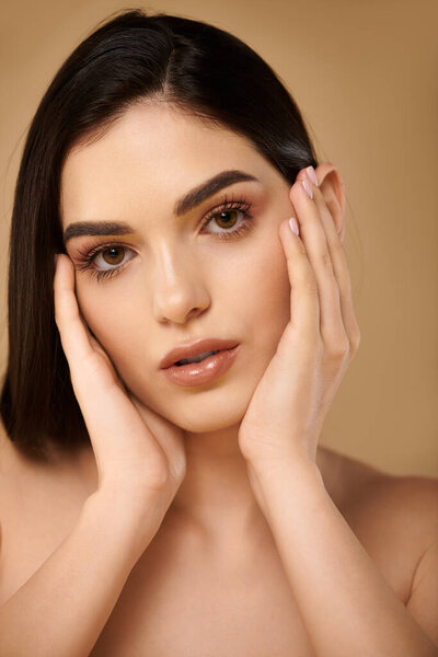 Young woman showcases radiant, healthy skin while posing gracefully in a well-lit studio.
