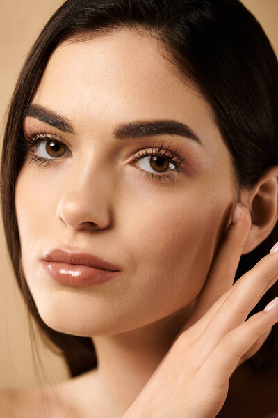 Молодая женщина подчеркивает свою светящуюся, безупречную кожу в студии красоты.