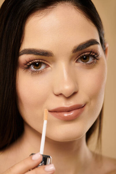 В студии, наполненной мягким освещением, молодая женщина подчеркивает свой сияющий, здоровый цвет лица.