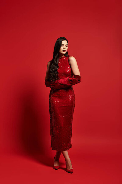 A young woman in a red dress and gloves creates an alluring atmosphere.