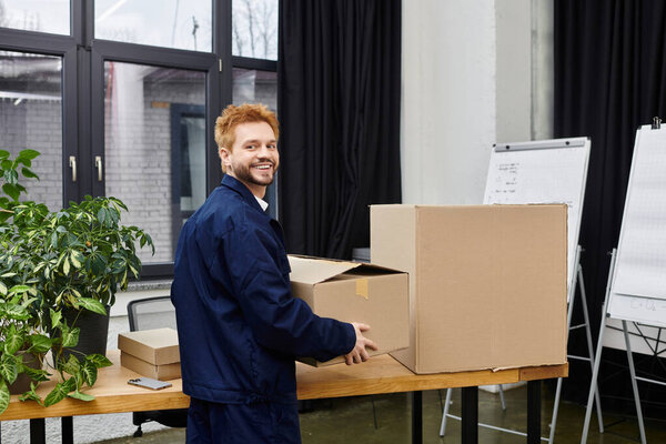 Man arranges packed boxes in a contemporary office environment during a busy relocation process.