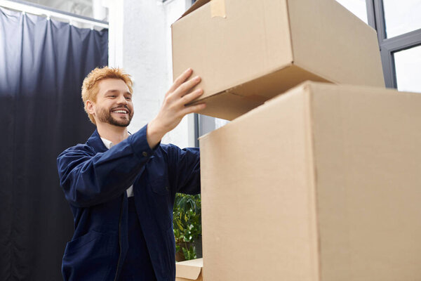 A cheerful worker stacks boxes carefully in a modern office during the move.