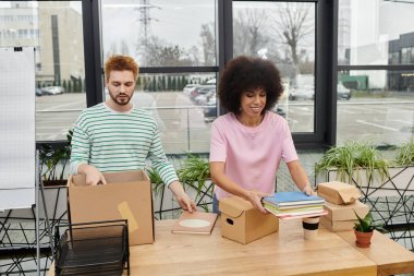 Taşınırken ofis malzemelerinin kutulanması için iki kişi işbirliği yapıyor..