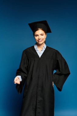 Genç bir kadın mezuniyet elbisesi ve şapkasıyla poz veriyor, mutluluk ve başarı saçıyor..