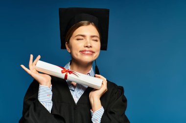 Mezuniyet kıyafetli genç bir kadın evde mutluluğunu ifade ederken diplomasını tutuyor.