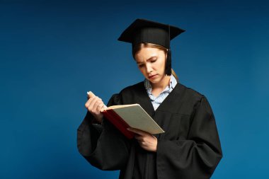 Mezuniyet elbisesi giymiş genç bir kadın, bir kitaba derinden odaklanmış, akademik başarıyı simgeliyor..