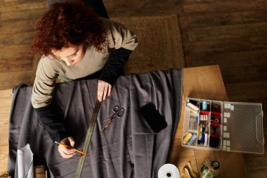 Genç bir kadın yeteneğini sergileyerek, DIY projesi için kumaşı ustalıkla ölçüyor..