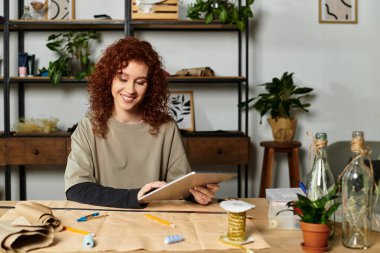 Genç bir kadın fabrika dolu çalışma alanında bir DIY projesi tasarlarken gülümsüyor..